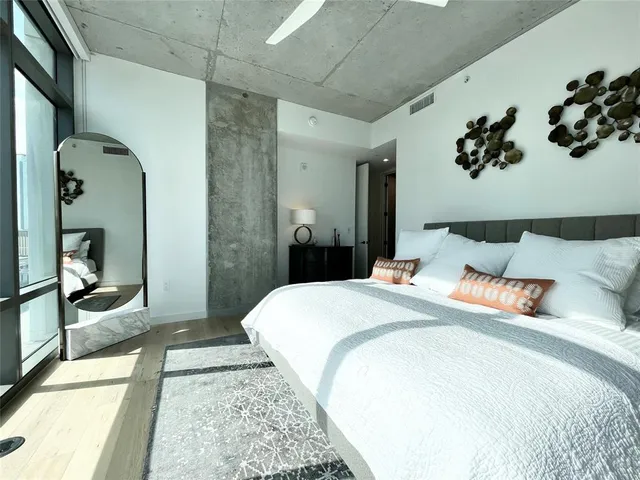 a bedroom with a large bed and a chandelier