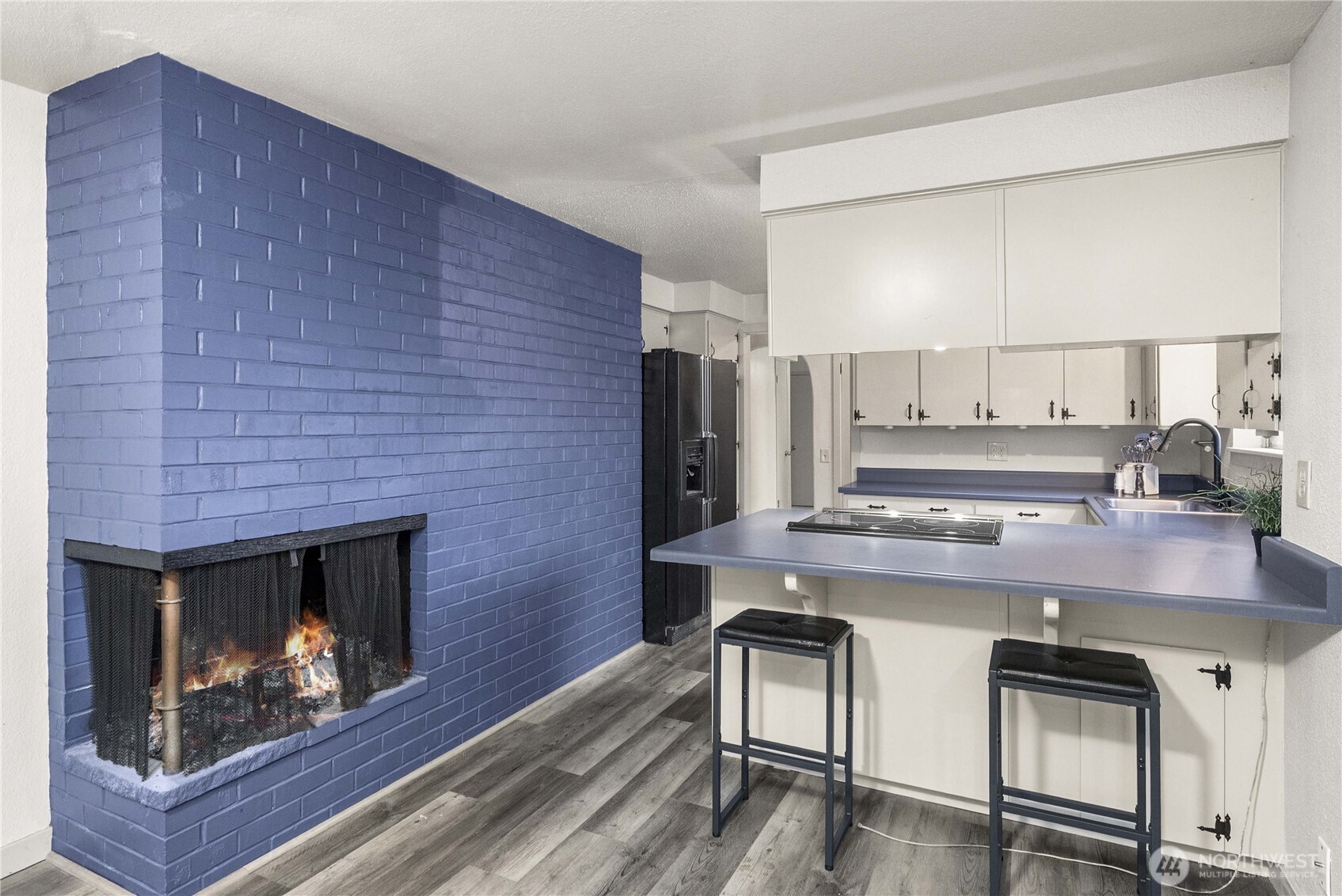 152 Christina Drive Sumner, WA 98390 - Photo 12 of 26 a kitchen with a wooden floor and a fireplace