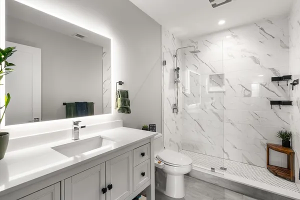 a bathroom with a double vanity sink toilet and shower