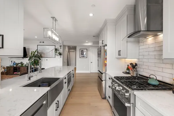 a open kitchen with stainless steel appliances granite countertop a sink stove and refrigerator