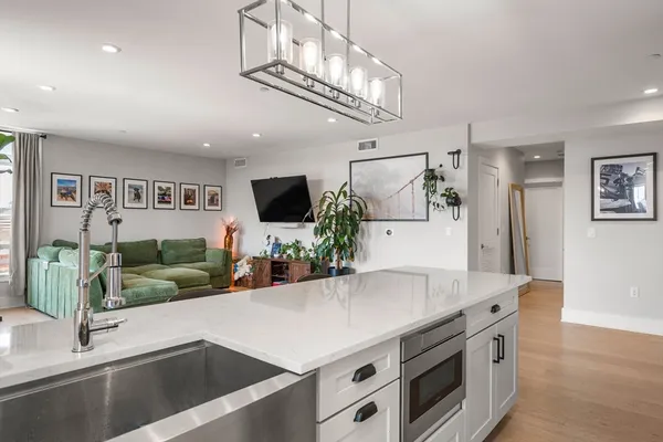 a kitchen with stainless steel appliances a white table chairs and a refrigerator