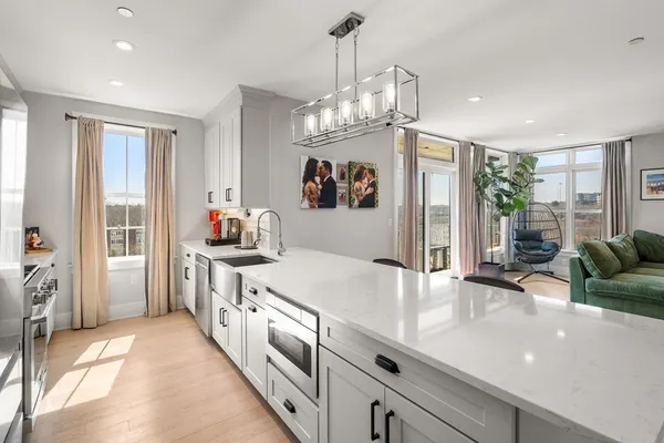 a kitchen with stainless steel appliances granite countertop a sink refrigerator and cabinets