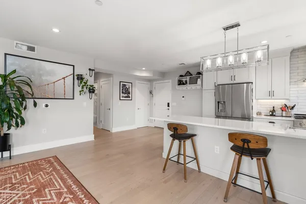 a kitchen with a table chairs refrigerator and microwave