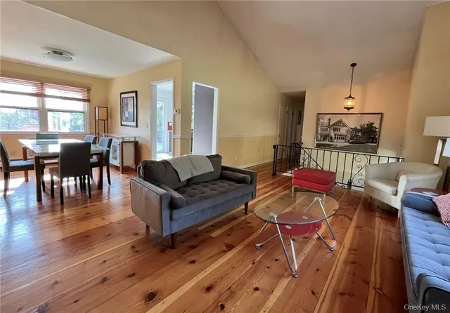 a living room with furniture a dining table and a wooden floor