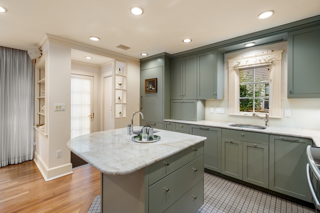 26 Healey Street Cambridge, MA 02138 - Photo 9 of 24 a kitchen with a sink dishwasher a dining table and chairs with wooden floor