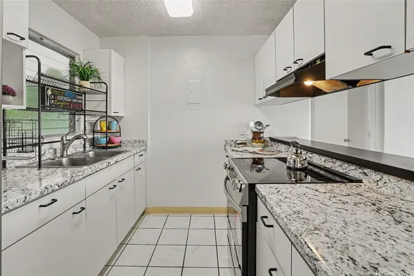 a kitchen with a sink a stove and cabinets
