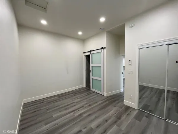 an empty room with wooden floor and entrance