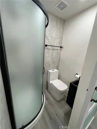 a white toilet sitting next to a white sink and vanity