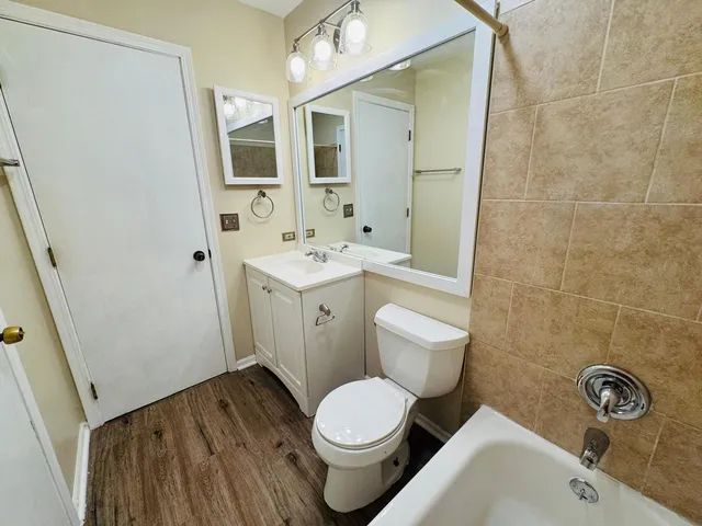 a white toilet sitting next to a bathroom sink and a mirror