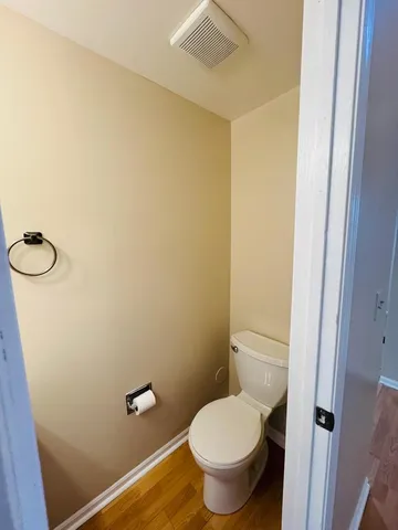 a white toilet sitting next to a shower