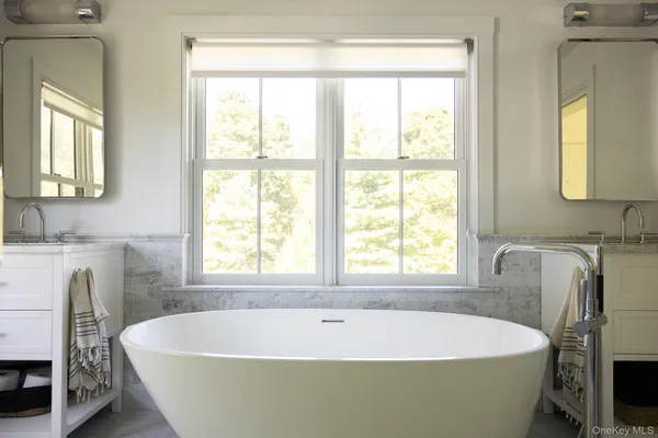 a white bath tub sitting in a bathroom next to a window