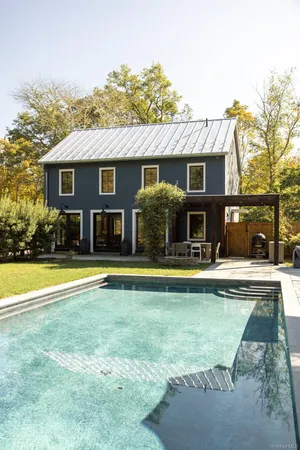 a view of swimming pool with seating area and barbeque oven