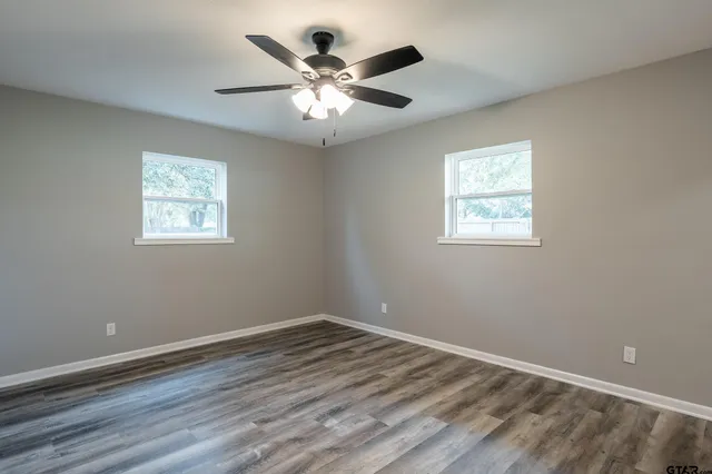 a view of empty room with wooden floor
