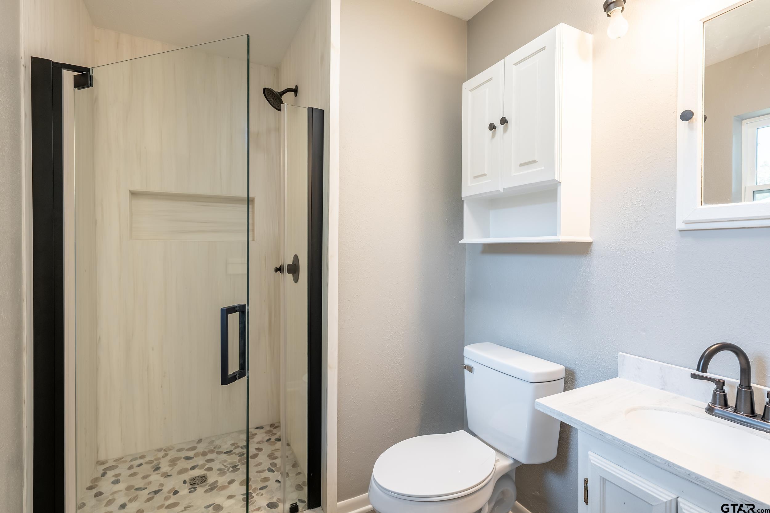 2201 King Road Jacksonville, TX 75766 - Photo 13 of 24 a white toilet sitting next to a bathroom sink