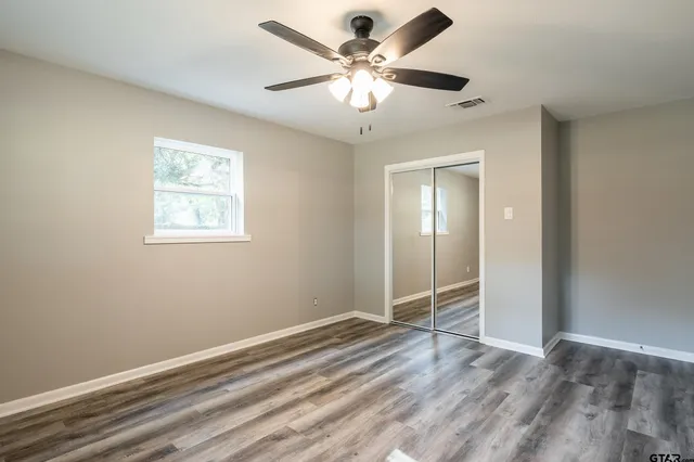 an empty room with fan and windows