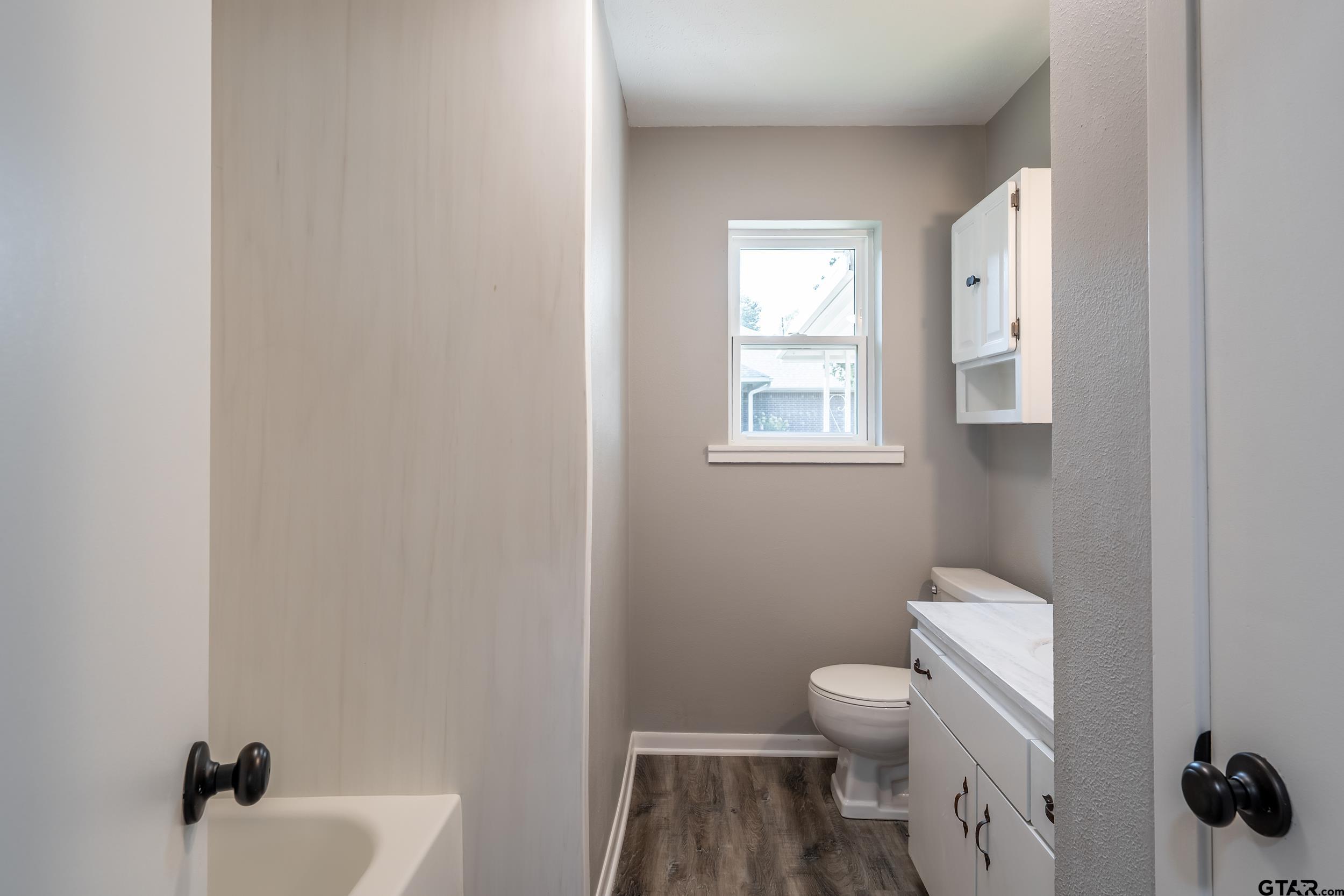 2201 King Road Jacksonville, TX 75766 - Photo 19 of 24 a bathroom with a toilet a sink and mirror