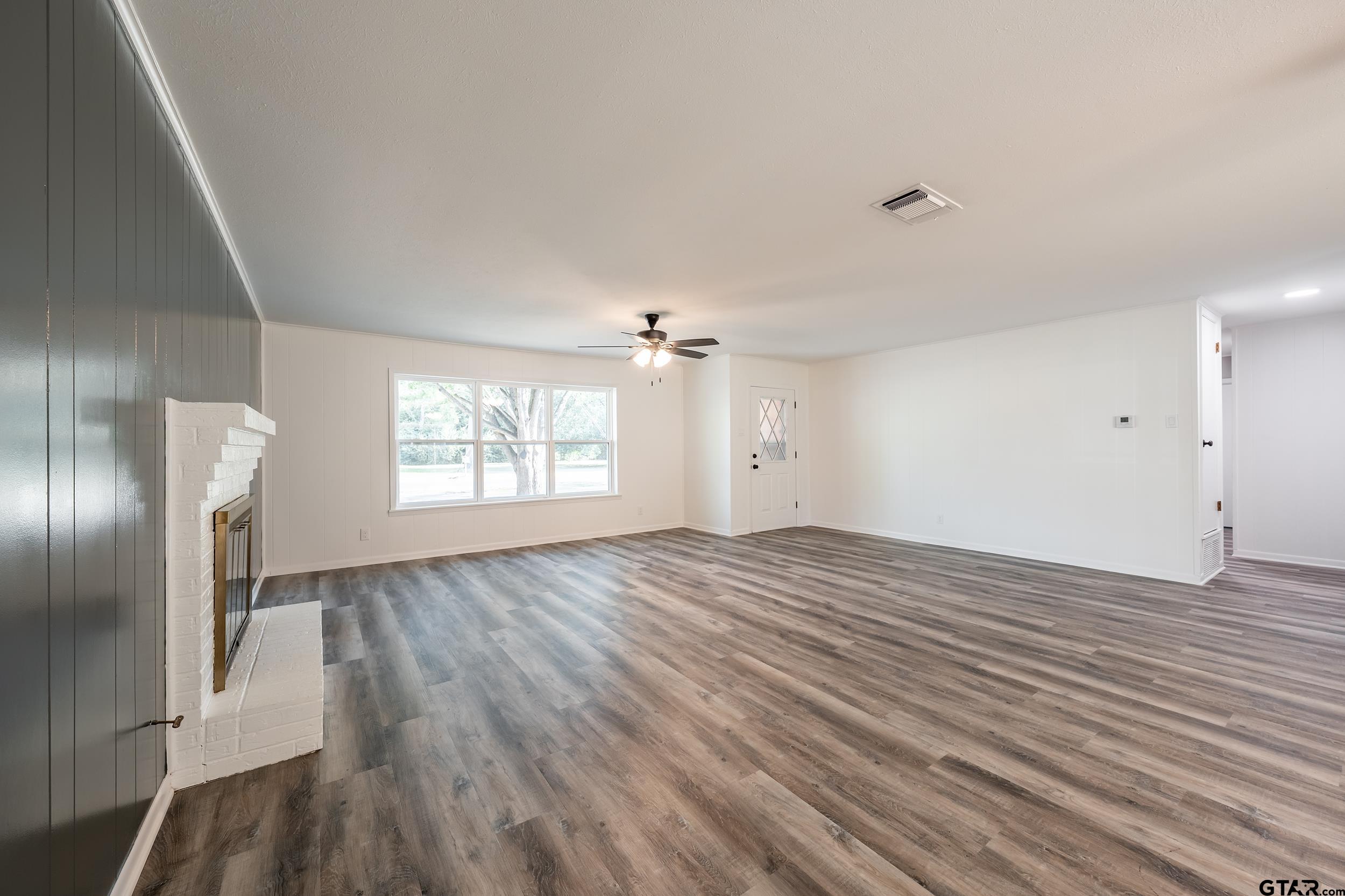 2201 King Road Jacksonville, TX 75766 - Photo 5 of 24 an empty room with wooden floor cabinet and windows