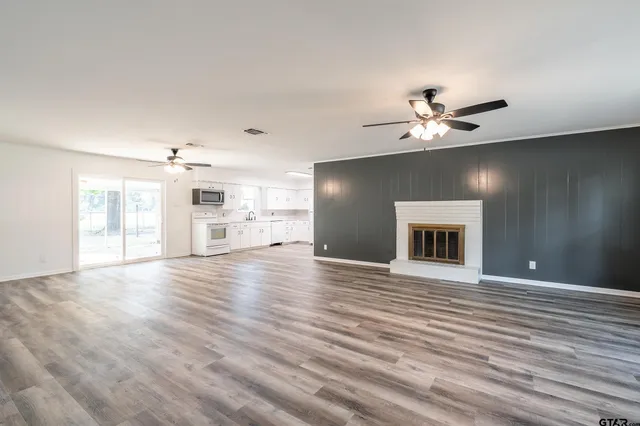a view of an empty room with window and wooden floor