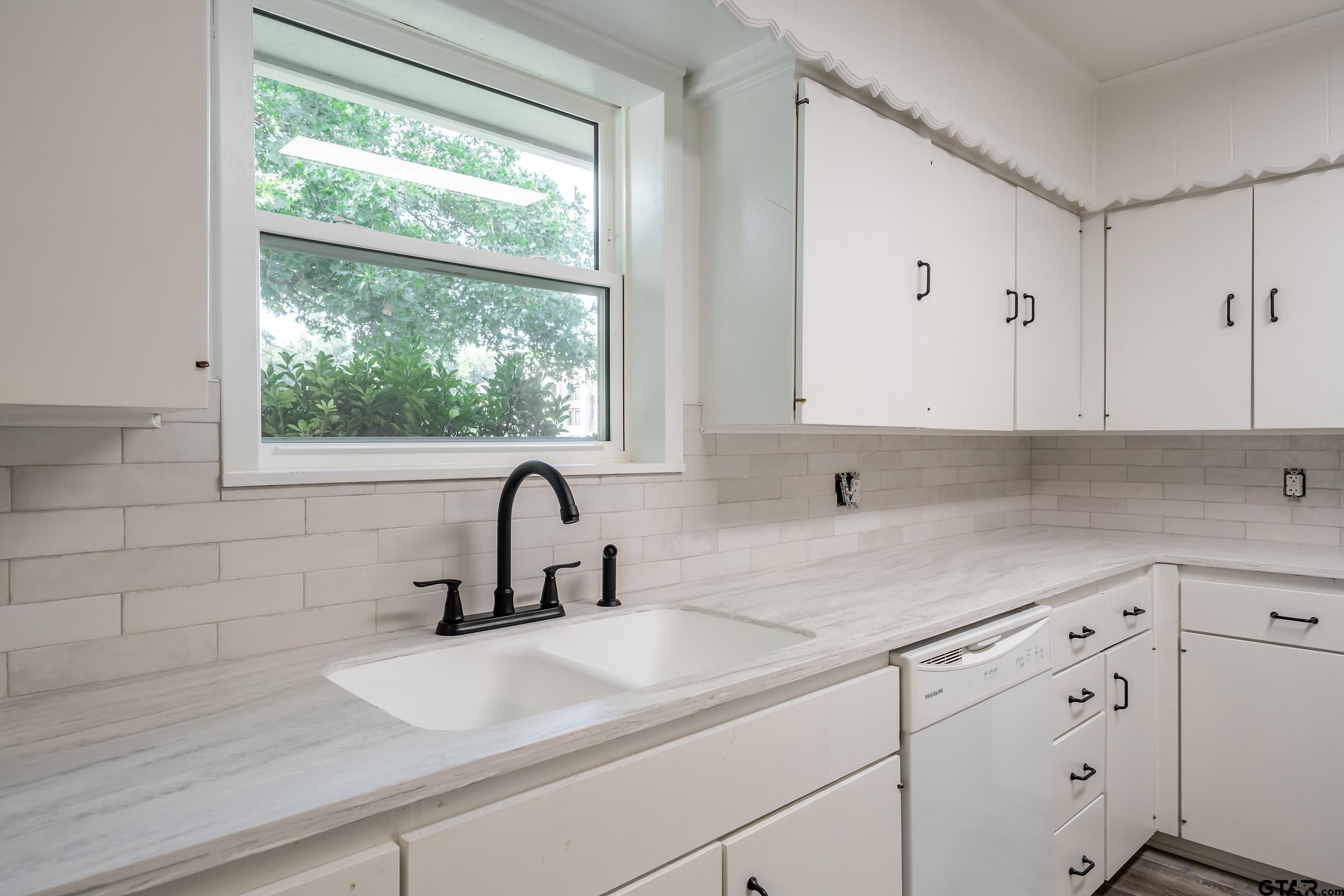 2201 King Road Jacksonville, TX 75766 - Photo 9 of 24 a kitchen with white cabinets a sink and a window