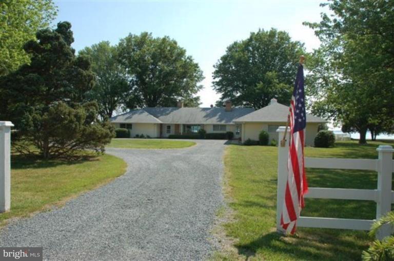 7188 Drum Point Road St. Michaels, MD 21663 - Photo 2 of 19 a front view of a house with a yard and trees