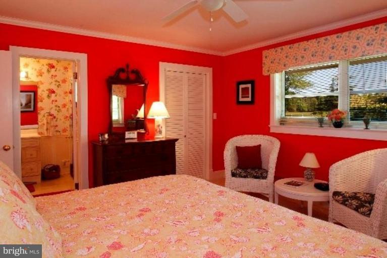 7188 Drum Point Road St. Michaels, MD 21663 - Photo 16 of 19 a bedroom with a bed and wooden floor