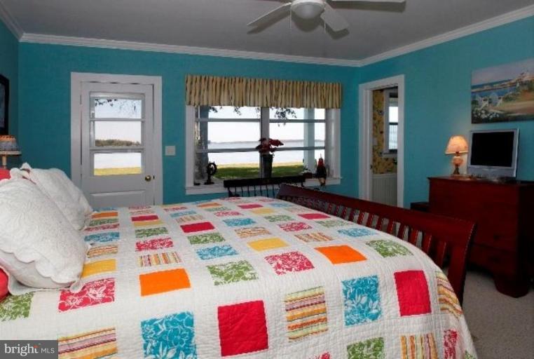 7188 Drum Point Road St. Michaels, MD 21663 - Photo 7 of 19 a bedroom with a bed a dresser next to a window