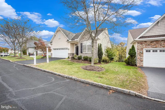 a view of a white house with a big yard and large tree