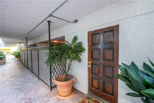 a front view of a house with entryway and a potted plant