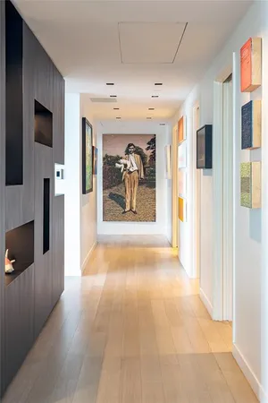 a view of a hallway with wooden floor and a living room