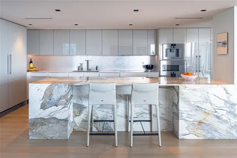 a kitchen with stainless steel appliances granite countertop a stove top oven a sink and a refrigerator