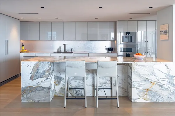 a kitchen with stainless steel appliances granite countertop a stove top oven a sink and a refrigerator