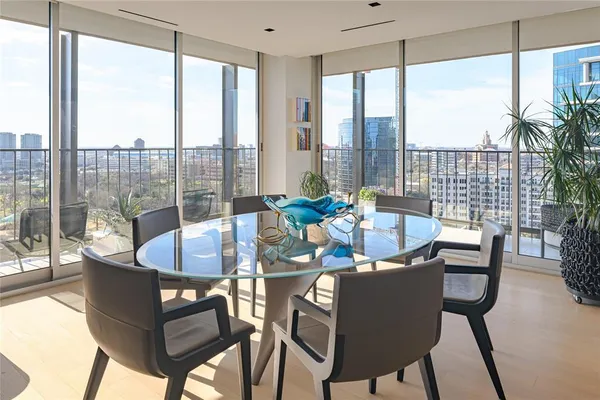 a dining room with furniture a chandelier and glass door
