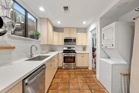 a kitchen with stainless steel appliances granite countertop a sink and a stove