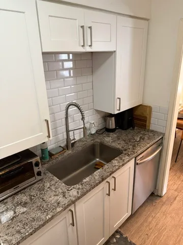 a kitchen with granite countertop a sink and a stove
