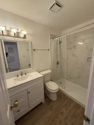 a bathroom with a double vanity sink toilet and shower