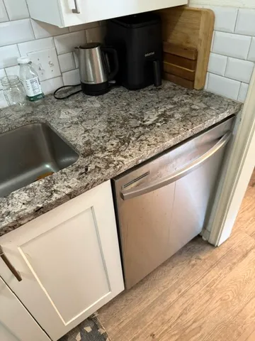 a kitchen with granite countertop a sink and a stove