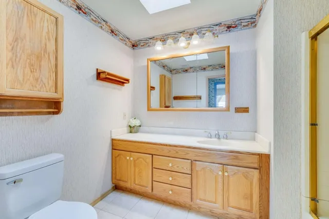 a bathroom with a granite countertop sink mirror and a toilet
