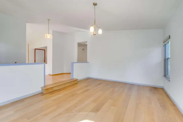 a view of empty room with wooden floor and ceiling fan
