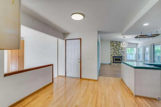 a view of a big room with wooden floor and windows
