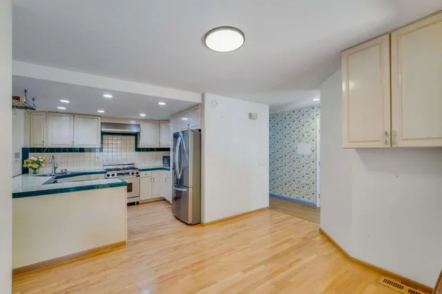 a kitchen with stainless steel appliances granite countertop a refrigerator and a stove top oven