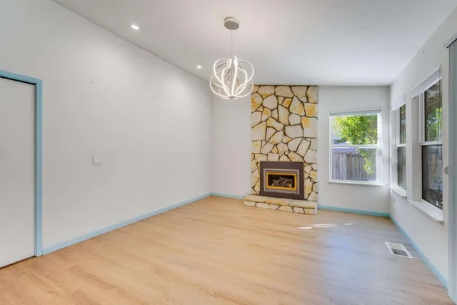 a view of an empty room with a fireplace and a window