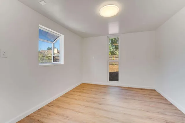 a view of empty room with wooden floor