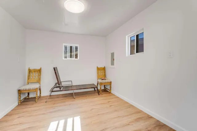 a view of a workspace with furniture and a wooden floor