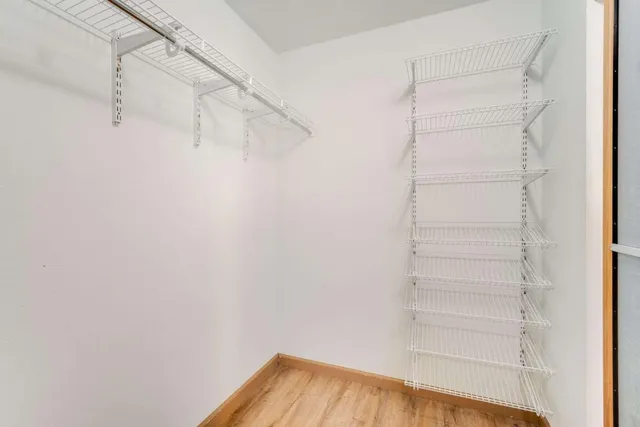 a view of walk in closet with empty racks