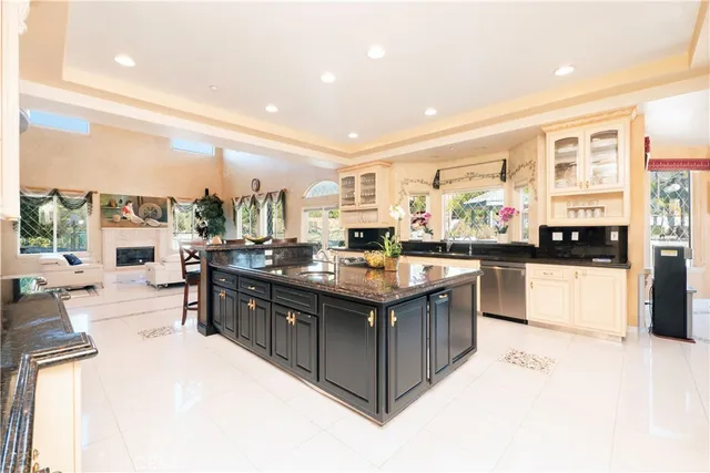 a living room with furniture kitchen view and a chandelier
