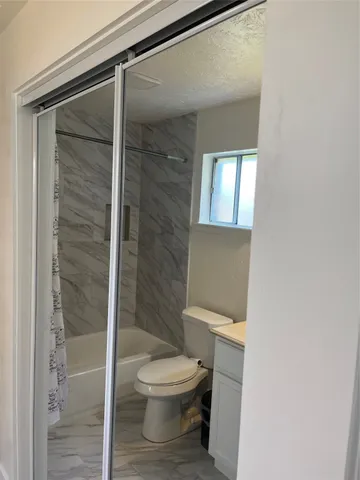 a bathroom with a toilet a sink a bath tub and shower