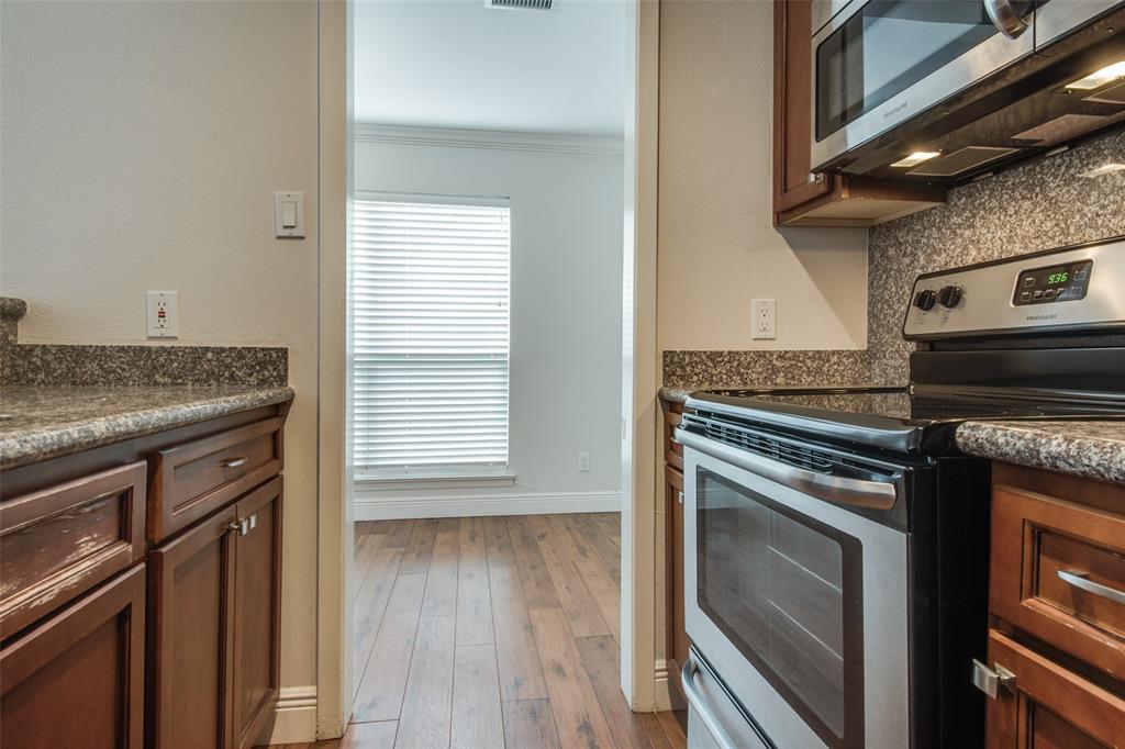 3907 Gilbert Avenue, Unit 8 Dallas, TX 75219 - Photo 5 of 11 a kitchen with granite countertop a stove and a microwave