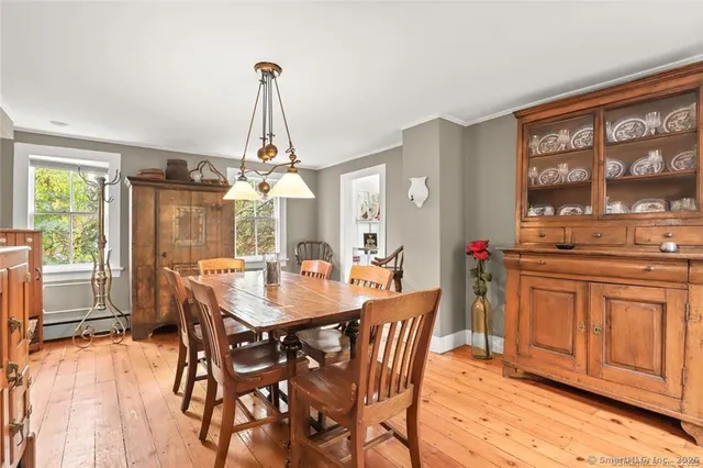 a dining room with furniture a chandelier and wooden floor