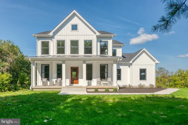 a front view of a house with yard and green space