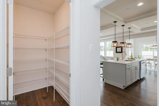 a kitchen with a sink a stove and chairs with cabinets
